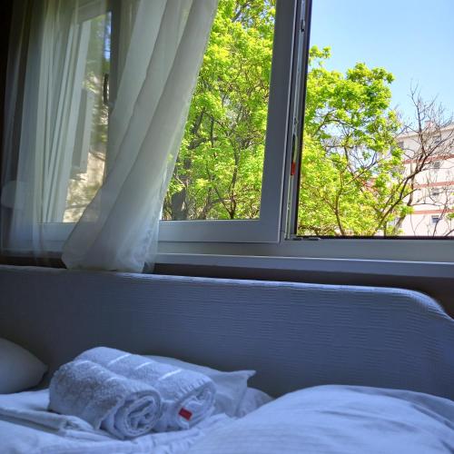 a bed with a window with a towel on it at Rivijera in Belgrade