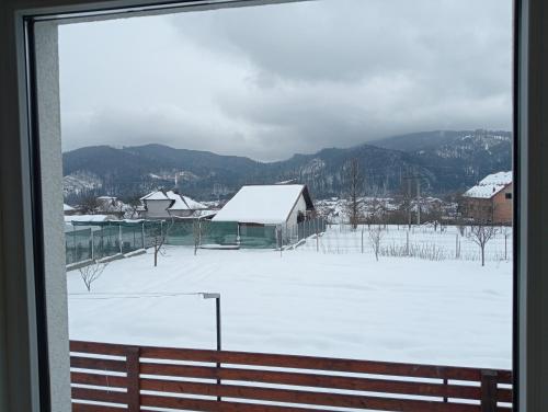a view of a snow covered field from a window at Casa Popa in Gura Humorului