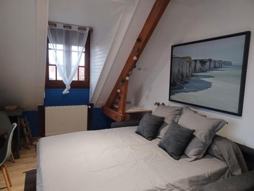 a bedroom with a white bed and a staircase at Studio Les Trois Clés in Fressenneville