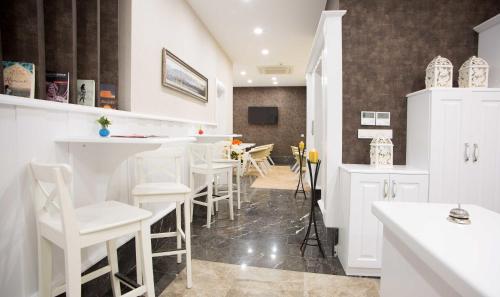 una cocina con barra con taburetes blancos en Astan Hotel Taksim, en Estambul