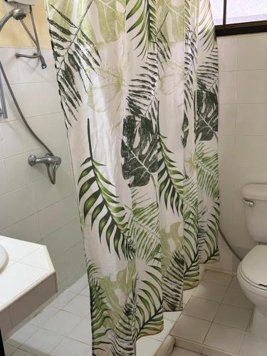 a bathroom with a green and white shower curtain at Samui Garden Resort in Bangrak Beach