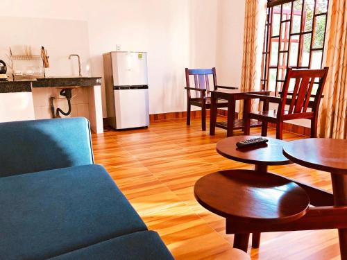 ein Wohnzimmer mit einem Sofa, Tischen und einem Kühlschrank in der Unterkunft VeLa Homestay in Phu Quoc