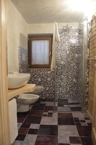 a bathroom with two toilets and a sink and a shower at Agriturismo La Collina in Pitigliano