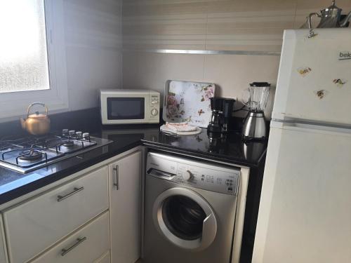 a kitchen with a refrigerator and a washing machine at Studio au bord de la corniche in Rabat
