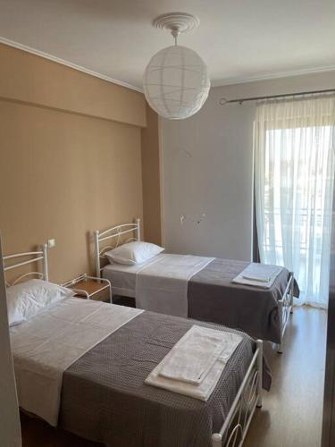 um quarto de hospital com duas camas e um lustre em Luxury apartment in Nafpaktos em Lepanto
