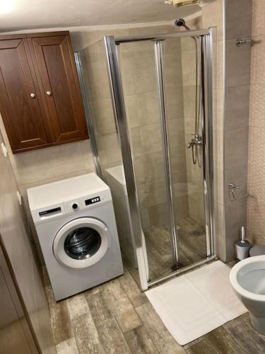 uma casa de banho com um chuveiro e uma máquina de lavar roupa em Luxury apartment in Nafpaktos em Lepanto