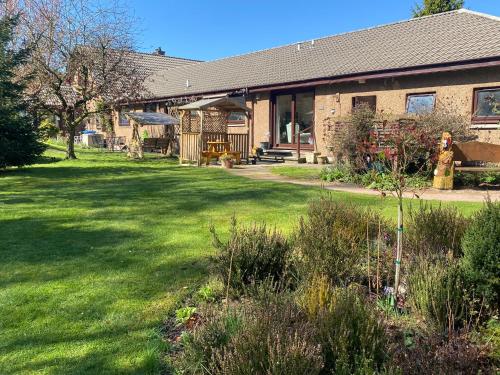 uma casa com um quintal com relva verde em Drummond Neuk - Pets Welcome! em Inverness