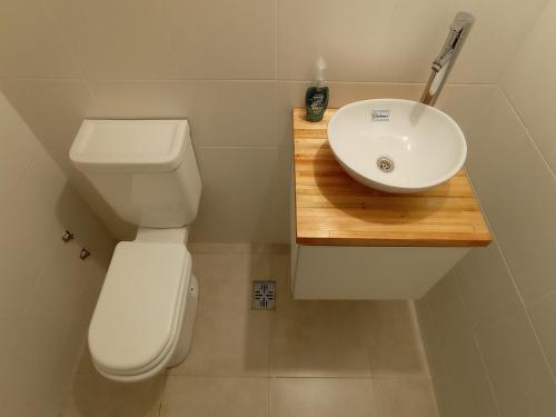 uma casa de banho com um WC branco e um lavatório. em Departamentos 2 ambientes en Mar del Plata em Mar del Plata