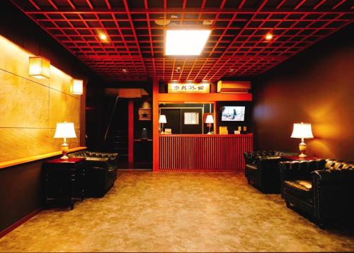 a room with chairs and a bar with a tv at Nara Ryokan in Nara