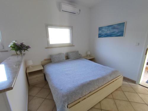 ein Schlafzimmer mit einem Bett in einem weißen Zimmer in der Unterkunft Appartamento da Vjeri in Pula