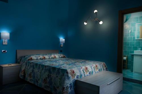 a bedroom with a bed and a blue wall at Casina Lambis in Pozzuoli