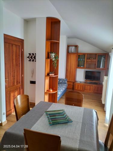 a dining room with a table and chairs and a kitchen at Grace's home in Bellano