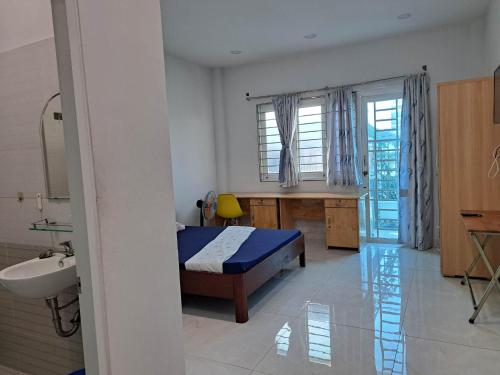 1 dormitorio con cama, escritorio y lavamanos en Homestay 37 AD en Ho Chi Minh