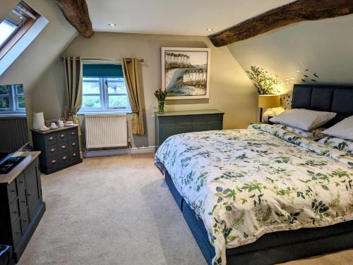 a bedroom with a large bed and a window at Worralls Grove Guest Farm House in Bewdley