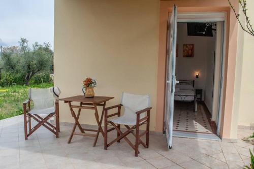 een patio met een tafel en stoelen en een slaapkamer bij Phyllida Guest House - A2 in Zakharo