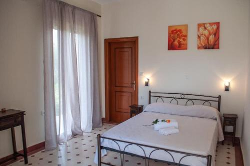 een slaapkamer met een bed met twee handdoeken erop bij Phyllida Guest House - A2 in Zakharo