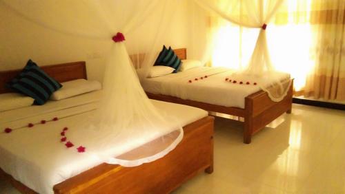um quarto com 2 camas com decorações vermelhas em Marvellous Inn em Ella