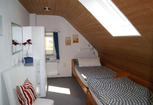 Zimmer mit 2 Betten und einem Dachfenster in der Unterkunft Ferienwohnung Ilsebill in Husum