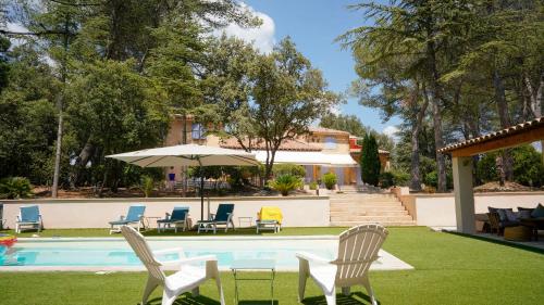 une piscine avec des chaises et un parasol à côté d'une maison dans l'établissement Maisonnette dans le Luberon - Bois Romay, à La Bastide-des-Jourdans