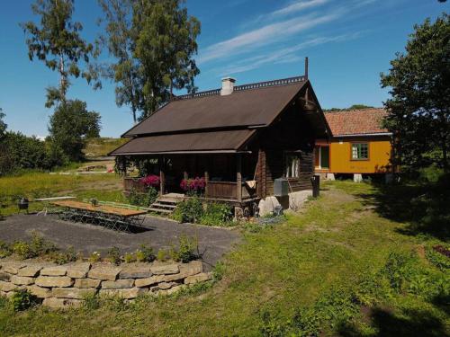 una casa en un campo con un jardín delante en Villa Leonore: Sommerhus m/strandlinje på Helgøya en Ringsaker