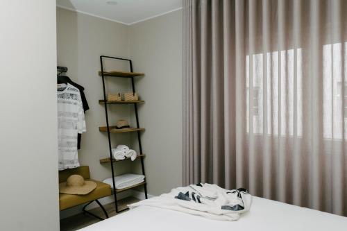 1 dormitorio con cama, estante y ventana en Casa dos Limos - Apartments, en Foz do Arelho