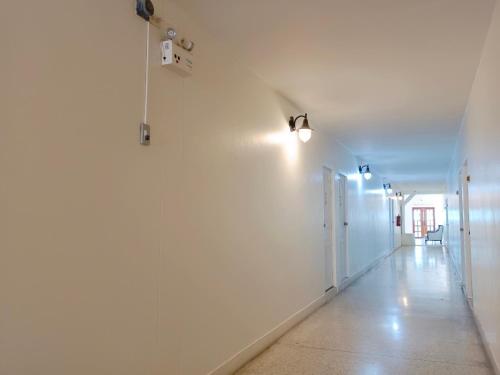 an empty hallway with white walls and lights at Bangsaphan Resort in Bang Saphan