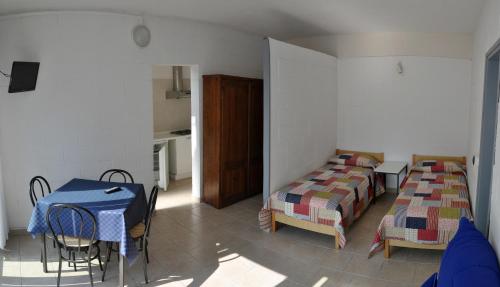 a room with a table and a bed and a table and chairs at Camping Villaggio Paradiso in Domaso