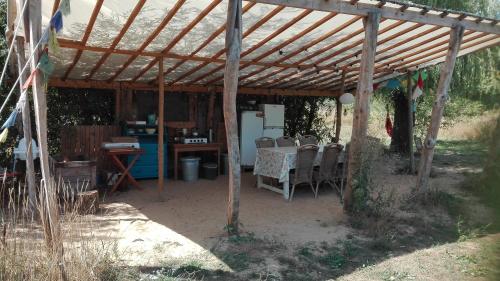 a patio with a table and chairs under a wooden pergola at Ecostay de Wildernis in Wilp