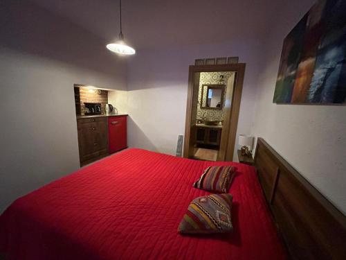 sypialnia z czerwonym łóżkiem i czerwonym kocem w obiekcie GorkyHouseUrla w mieście Ildır