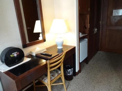 a desk with a lamp and a mirror in a hotel room at Kyu Karuizawa Hotel Otowa No Mori in Karuizawa