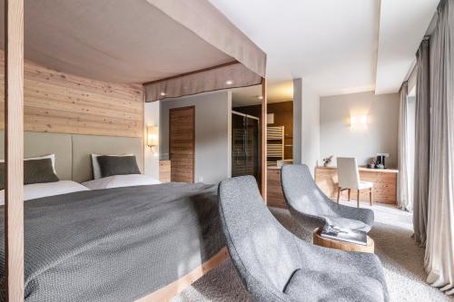 a bedroom with a large bed and two chairs at SILENA, your soulful hotel - adults only in Valles