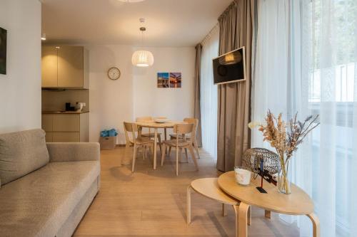 een woonkamer met een bank en een tafel bij Sunset Apartment in Juodkrantė