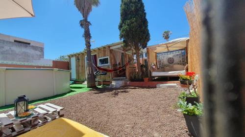 um quintal com uma casa com rede e palmeiras em Romantic Woodhouse casita camping em Aguatona