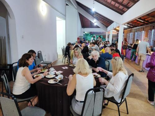 a group of people sitting at a table eating food at Tekoma Resort Taman Negara in Kuala Tahan