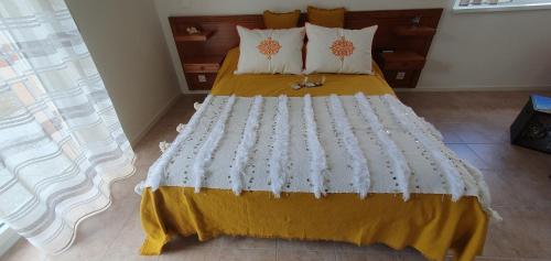 ein Schlafzimmer mit einem großen Bett mit gelber Bettwäsche und Kissen in der Unterkunft L'Aurosée in Savièse