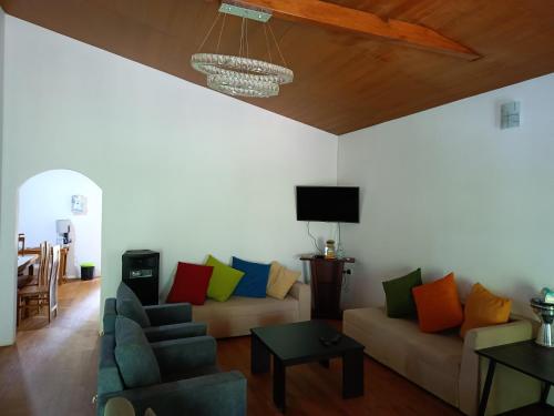 sala de estar con sofá y almohadas coloridas en Sarah Holiday Resort, en Haldummulla