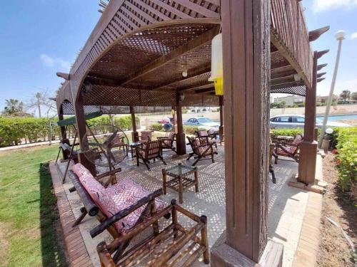 a patio with wooden benches and tables and a pavilion at فيلا مارينا٥ على البحيره ٥ غرف in El Alamein