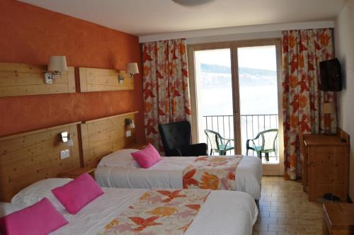 a hotel room with two beds and a balcony at Hotel Lou Granva in Grande Riviere