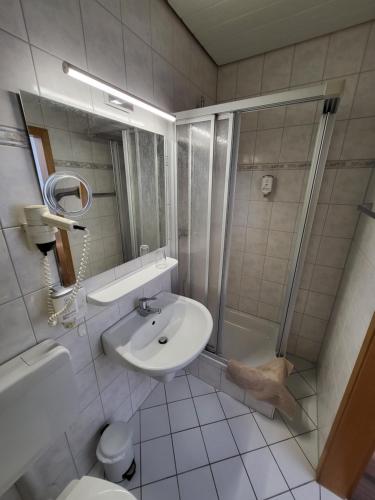 a bathroom with a sink and a shower and a toilet at Bergischer Hof - Bergischer Hofgarten in Windeck