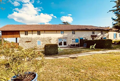 a stone house with a garden and a yard at L'Adéenne in Gondrin