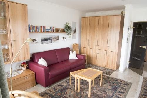 a living room with a purple couch and a table at Frische Brise FeWo 06 01 in Cuxhaven