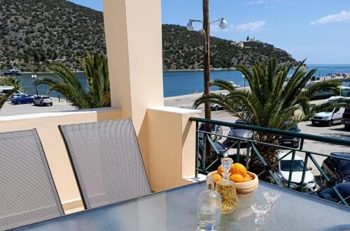a table with a bowl of oranges on a balcony at Hermione Port Luxury Residence in Ermioni