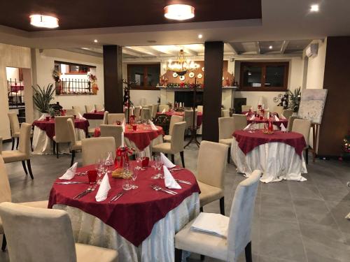 a restaurant with tables and chairs with red tablecloths at Locanda Rossa in Romans di Varmo