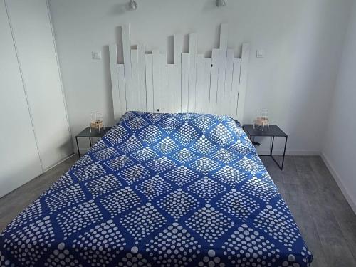 - une chambre avec un lit bleu et 2 tables dans l'établissement Le Krogen, à Locmiquélic