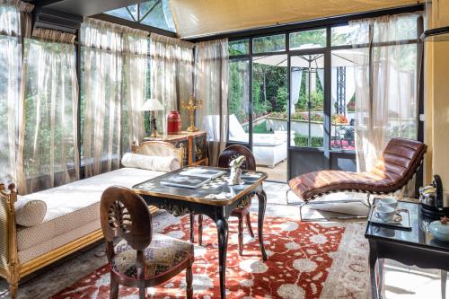 a living room with a bed and a table and chairs at Villa Gallici Hôtel & Spa in Aix-en-Provence