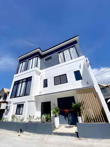 uma casa branca com janelas pretas em NEW Modern Suite near Airport & Beach em Sudtungan