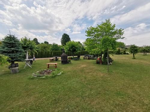 a park with a bunch of picnic tables and trees at Agrostrzecha in Ryczów