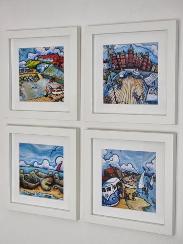 four framed drawings of the same painting on a wall at The Garden Suite Holt in Holt