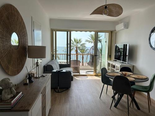 La Couronne Appartement a Nice في نيس: غرفة معيشة مع طاولة وإطلالة على المحيط