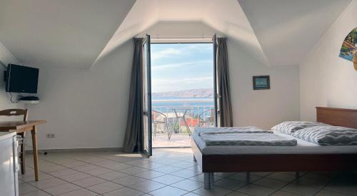 a bedroom with a bed and a view of the ocean at Apartment Anic in Karlobag